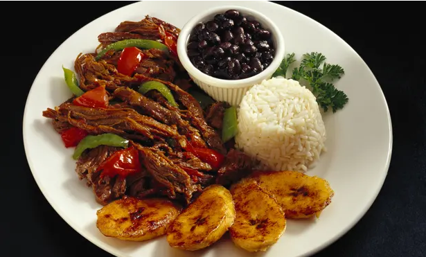 Ropa Vieja: This dish consists of shredded beef cooked with tomatoes, onions, and peppers, and is often served with rice and beans. One of the best places to try this dish is at La Guarida, a famous restaurant located in Havana.