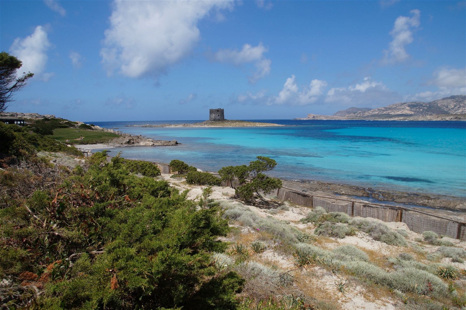 La Pelosa Beach: Located in the town of Stintino, La Pelosa Beach is one of Sardinia's iconic beaches. It is characterized by its fine white sand, crystal-clear waters, and stunning views, including a historic Aragonese tower.
